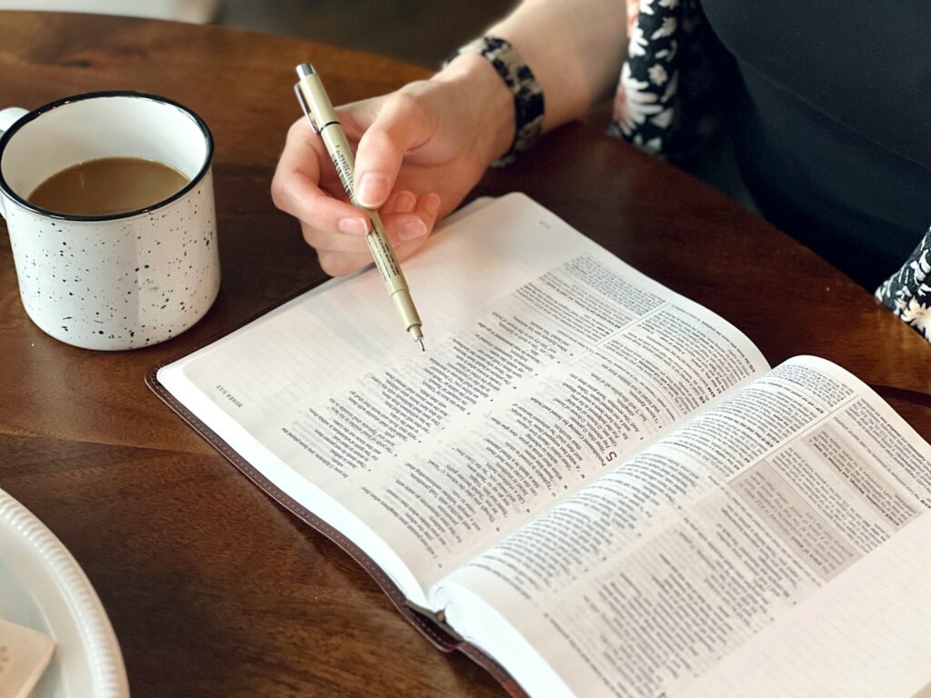 a person sitting at a table with a book and pen